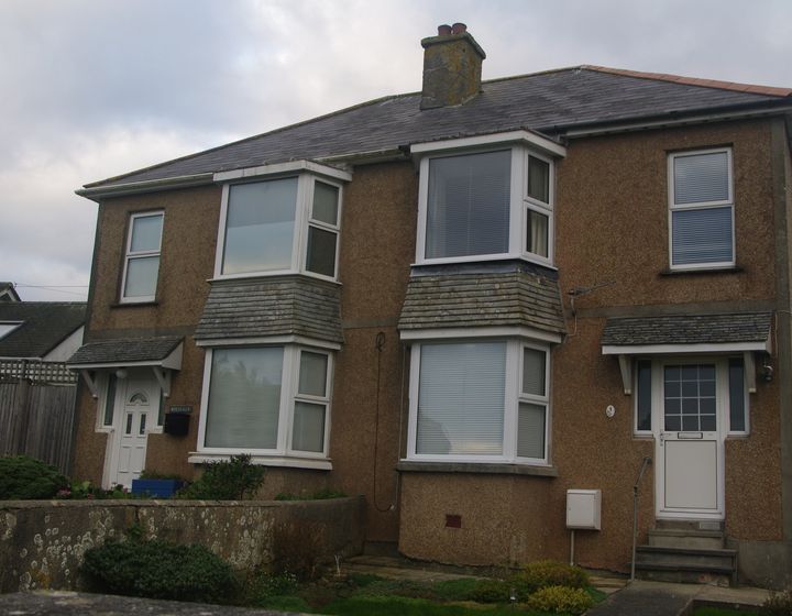 A UK semi-detached house with modern windows and a front door.